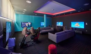 a waiting room with couches and televisions at Aminess Vival Maestral Hotel in Novigrad Istria