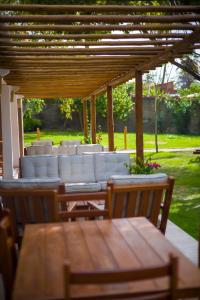 a wooden table and chairs under a wooden pergola at Villa Jaguar Fortim in Fortim