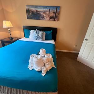 Un dormitorio con una cama azul con toallas. en #2BR Escape - Near Stone Mountain park en Lithonia