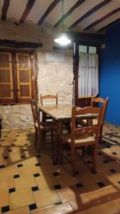 comedor con mesa de madera y sillas en La Cueva Colosal, en Alcalá del Júcar