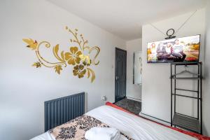 a bedroom with a bed and a tv on a wall at *RB26S* For your most relaxed & Cosy stay + Free Parking + Free Fast WiFi * in Adel