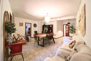 sala de estar con sofás blancos y comedor en Casa Rural - La Fresquita, en Castaño de Robledo