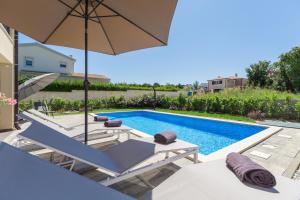 a villa with a swimming pool and an umbrella at Villa Opal in Tar