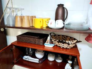 a wooden shelf with cups and dishes on it at Chalé da cachoeira - Ilhabela in Ilhabela +13 photos