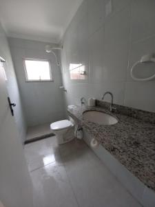 Baño blanco con lavabo y aseo en Edif Elias Pinto Coelho, apto.404, en Guarapari