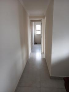 um corredor vazio com uma janela num quarto branco em Edif Elias Pinto Coelho, apto.404 em Guarapari