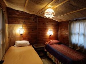 1 dormitorio con 2 camas en una habitación con paredes de madera en el portal de laguna de zapallar ,maitencillo, en Zapallar