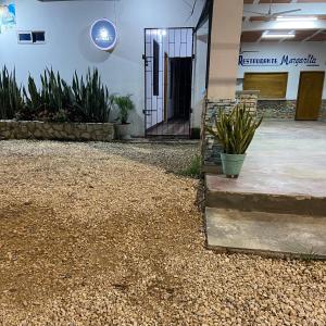a front door of a building with gravel and plants at Mónaco habitaciones in Coveñas