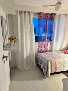 1 dormitorio con 1 cama frente a una ventana en Cobertura Recreio dos Bandeirantes, en Río de Janeiro