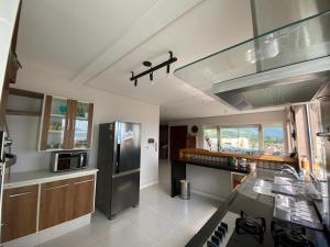 a kitchen with a stainless steel refrigerator and a counter at Vista Maravilhosa do Mar! in São Sebastião