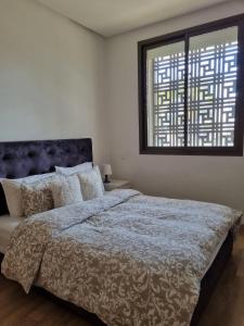 a bedroom with a large bed and a window at Appartement a la marina de salé in Salé