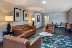 uma sala de estar com um sofá, cadeiras e uma mesa em Extended Stay America Suites - Arlington - Six Flags em Arlington