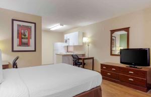 a hotel room with a bed and a flat screen tv at Extended Stay America Select Suites - Raleigh - RDU Airport in Morrisville