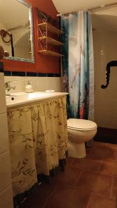 y baño con lavabo, aseo y cortina de ducha. en Las Cuevas Del Abismo, en Alcalá del Júcar