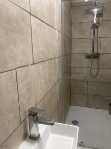 a bathroom with a sink and a shower at Home from Home in Merton