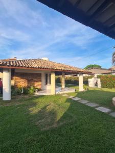 een huis met een grasveld met een dak bij Casa na Ilha de Mar Grande in Vera Cruz de Itaparica
