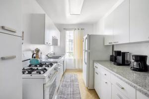 uma cozinha branca com um fogão e um frigorífico em Spacious 2 Bedroom 2 Bathroom Unit Great Location em Los Angeles