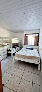 een slaapkamer met een bed en 2 stapelbedden bij Casa na Ilha de Mar Grande in Vera Cruz de Itaparica