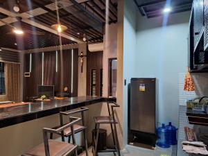 um bar com três bancos numa cozinha com frigorífico em Bora House em Bago