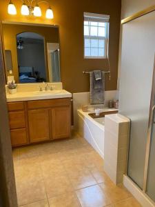 a bathroom with a tub and a sink and a mirror at Spacious & Sunny South Reno Home, Near Trails & Shopping 3 beds in Steamboat