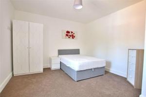 a bedroom with a bed and a cabinet in it at Hood St in Kingsthorpe