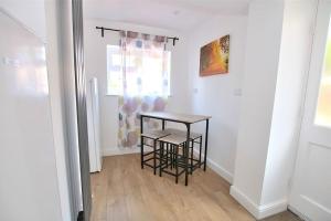 a table and two stools in a room with a window at Hood St in Kingsthorpe