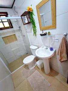 e bagno con servizi igienici, lavandino e doccia. di Chalé da cachoeira - Ilhabela a Ilhabela