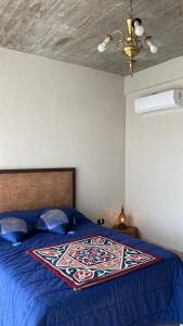 1 dormitorio con 1 cama con edredón azul en Relax de campo en Ezeiza