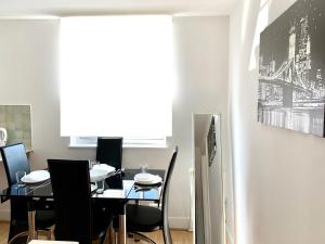 a dining room with a black table and chairs at Tower Bridge London, 2 Bedrooms, Reception, Kitchen, Parking in London