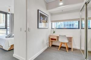 Dormitorio con escritorio, cama, escritorio y silla en Charlotte Towers Brisbane & Resort Style Facilities, en Brisbane