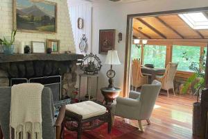 un salon avec une cheminée et une salle à manger dans l'établissement Enchanted Woodstock Cottage with hot tub, 