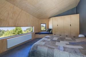 1 dormitorio con cama y ventana grande en Bivvy House Of The Year Winner, en Queenstown