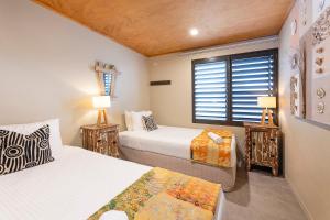 Un dormitorio con dos camas y una ventana. en Driftwood Shores, en Forster