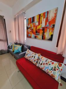 ein Wohnzimmer mit einem roten Sofa und einem Gemälde in der Unterkunft Newport's STAR in Manila