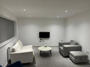 a living room with two chairs and a flat screen tv at All Seasons Northern Quarter Manchester in Manchester