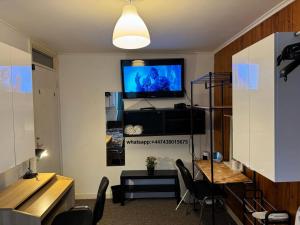 - un salon avec une télévision, une table et des chaises dans l'établissement 3- Room in central London, à Londres