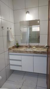 a bathroom with a sink and a mirror at Casa Caminho da Alvorada in Parnaíba +13 photos