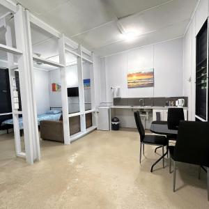 una habitación con mesa y sillas y un dormitorio en Unit 1 Golden Sands Retreat, en Wagait Beach