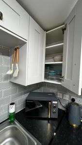 a kitchen with a sink and a microwave at London charming bedroom flat in London