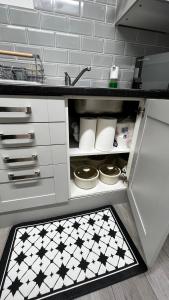 una cucina con lavandino e piastrelle bianche e nere di London charming bedroom flat a Londra