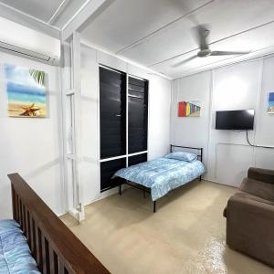 a small room with a bed and a couch at Unit 1 Golden Sands Retreat in Wagait Beach