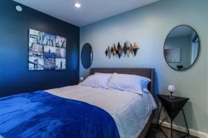 a blue bedroom with a bed and two mirrors at Discover the Ultimate Trending Hot Tub Retreat in El Paso