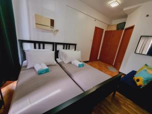 uma cama grande com duas almofadas num quarto em Newport's STAR em Manila