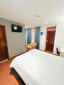 伊瓦拉的住宿－Quinta San Carlos Hostel，酒店客房,配有白色的床和椅子