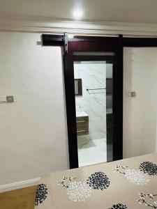 Habitación con cama, espejo y puerta en Not Like The Rest of ‘Em! en Lagos