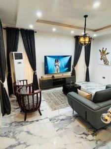 a living room with a couch and a flat screen tv at Not Like The Rest of ‘Em! in Lagos