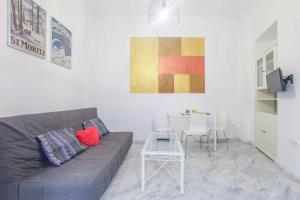ein Wohnzimmer mit einem Sofa und einem Tisch in der Unterkunft GALINDO CENTER PREMIUM SUITES, Free Parking in Sevilla