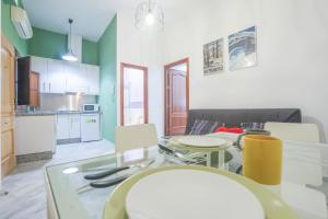 eine Küche und ein Esszimmer mit einem Tisch und Stühlen in der Unterkunft GALINDO CENTER PREMIUM SUITES, Free Parking in Sevilla