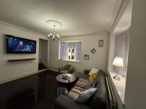 a living room with a couch and a table at Idyllic Cottage in Jubilee Park in London