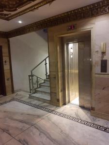 a lobby with a staircase and a glass door at Qurban Apartment in Al ‘Awālī